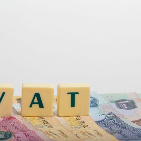 Stacks of  dirham banknotes with the letters VAT  (Value Added Tax) isolated on white background